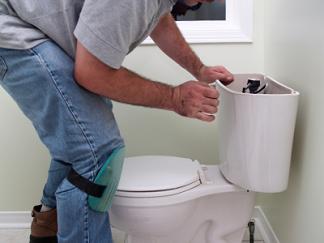 Plumber in Arlington Texas repairs a toilet